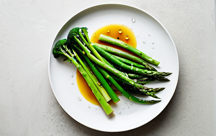 A professional food photograph showcasing a vibrant assortment of perfectly steamed vegetables on a pristine white serving dish. Bright green broccoli florets, slender asparagus spears, and tender green beans are arranged artfully, maintaining their vivid colors and tender-crisp texture. Tiny dewy water droplets are visible on the surfaces, emphasizing freshness and moisture. Soft, natural light illuminates the scene, highlighting the healthy and appetizing qualities. A minimalist, clean background. Safe for work, appropriate content, fully clothed, professional, family-friendly, perfect anatomy, correct proportions, natural pose.